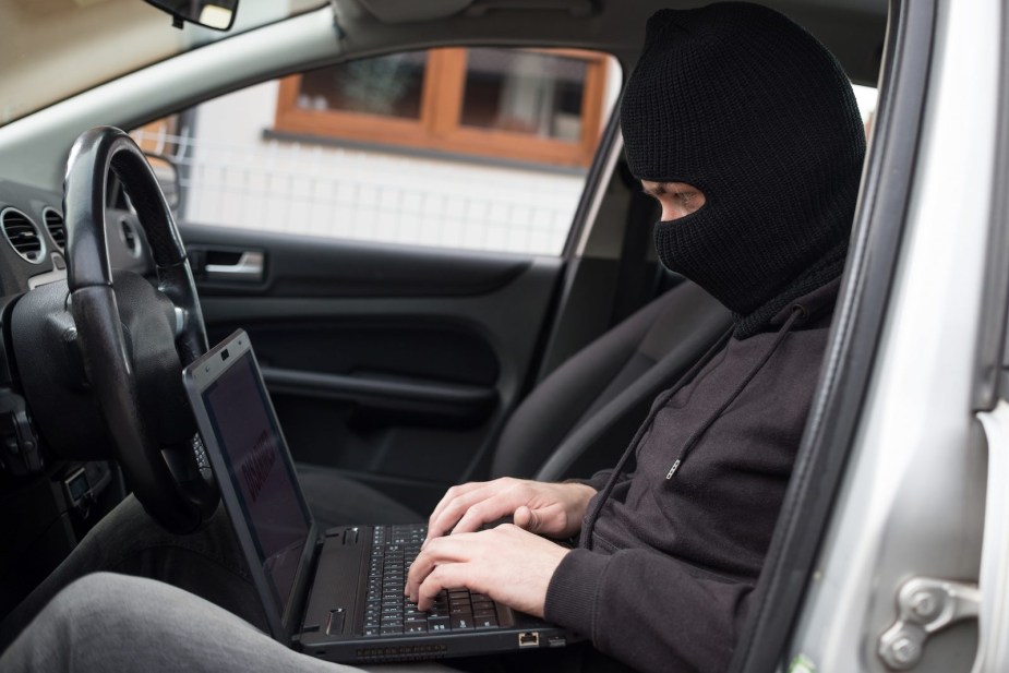 Auto theft in progress as a man hacks a sedan.