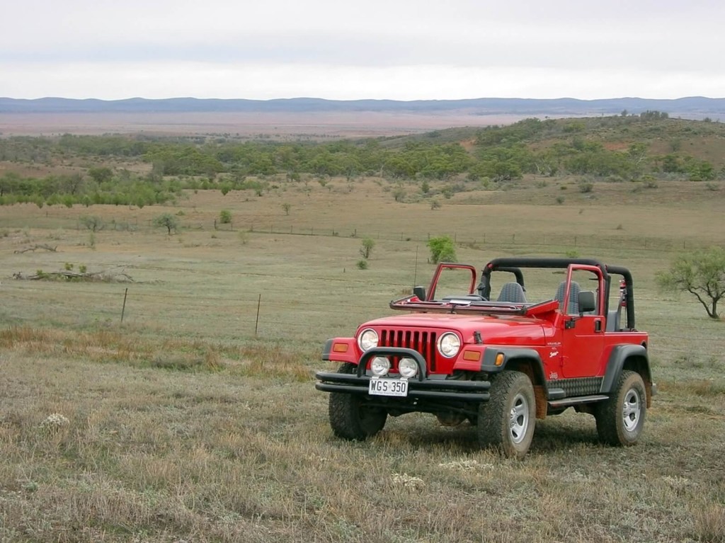 A Jeep Wrangler TJ with its windshield folded in keeping with the model's history.