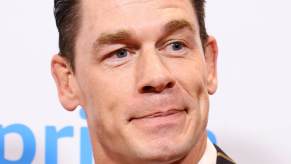 A smirking John Cena takes a picture at an event.