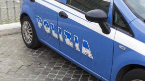 The side of an Italian police car marked with the word 'Polizia'.