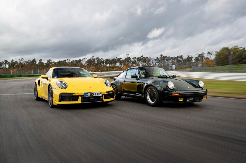 A pair of Porsche 911s, one 992 and a 930, cruise on the track.