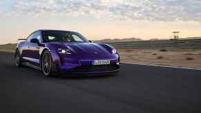 A purple Porsche Taycan Turbo GT with Wiessach package in right front angle view driving on a desert track