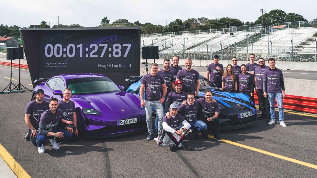 The Porsche development team gathers around the 2024 Porsche Taycan Turbo GT after driver Lars Kern sets the Laguna Seca EV lap speed record