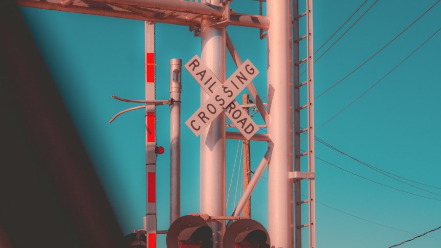 The crossed railroad crossing sign and red stop lights at a track.