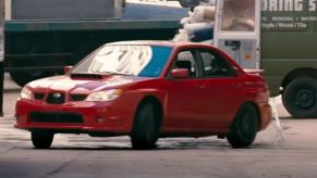 A red 2006 Subaru Impreza WRX slides in Baby Driver.