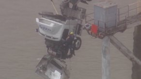 A firefighter rescues a truck driver from a semi-truck crash.
