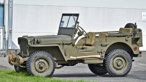 An olive-drab green Willys MB, one of the vehicles involved in the origin of the Jeep name, at a reenactment.