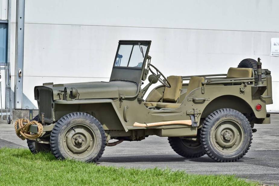 An olive-drab green Willys MB, one of the vehicles involved in the origin of the Jeep name, at a reenactment.