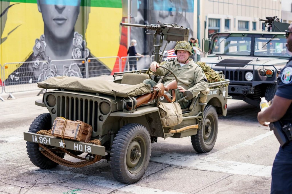 A reenactor with a Willys MB Jeep in a parade. 