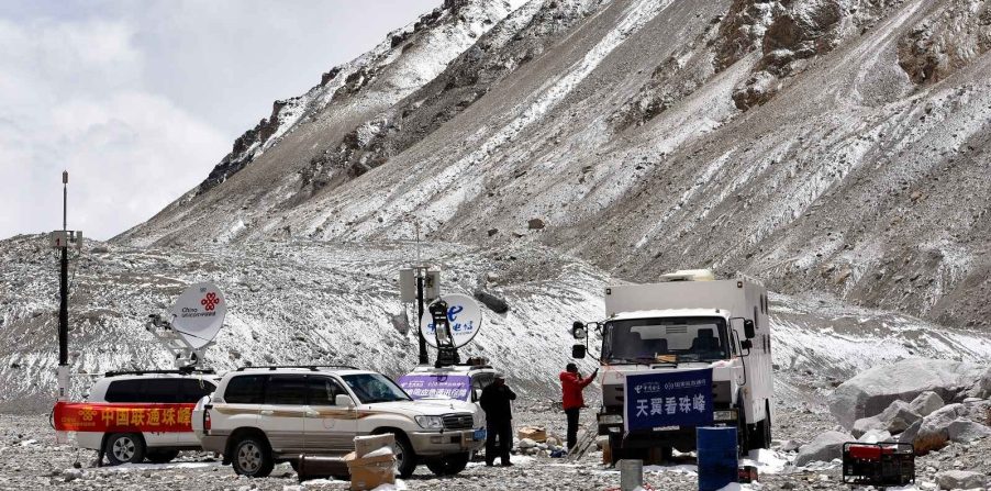 Several SUVs and a commercial truck parked at Everest Base Camp North in Tibet