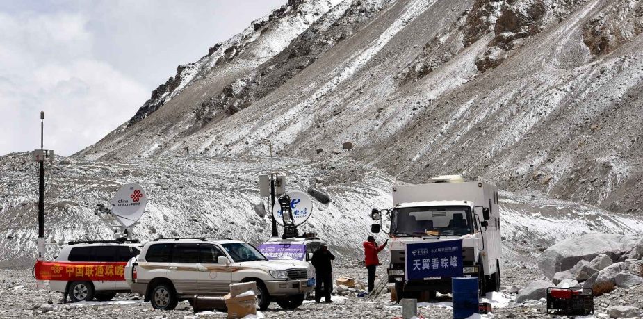 Several SUVs and a commercial truck parked at Everest Base Camp North in Tibet