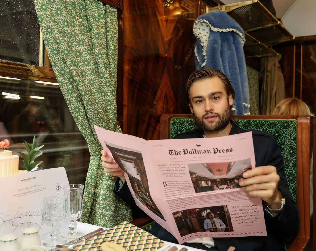 Actor Douglas Booth sits in the Cygnus carriage of the British Pullman train after Wes Anderson redesigned it in 2021
