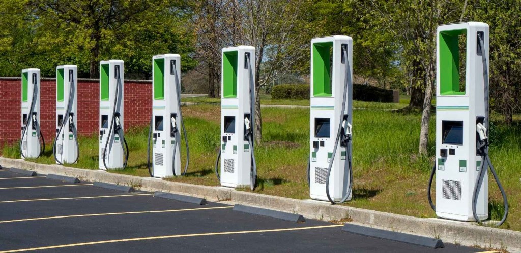 A row of EV chargers at a public station parking spots