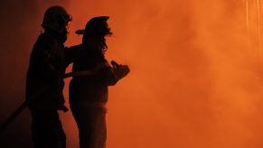 Firefighters battle a smoky fire.