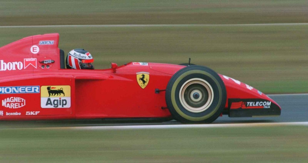 Gerhard Berger driving in a red Ferrari Formula One racecar in 1995 in right profile view