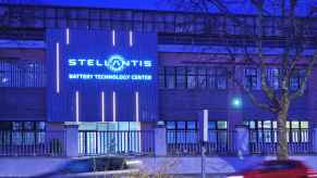 The front of the Stellantis Battery Technology Center is lit up in blue lights dusk