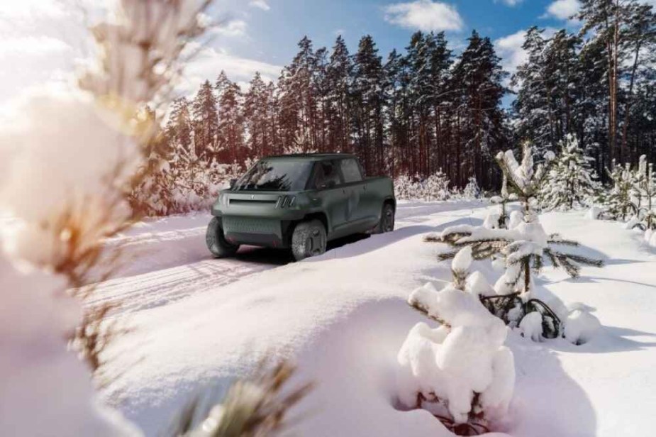 A rendering of a dark green colored Telo subcompact pickup driving in a heavily snow covered forested climate
