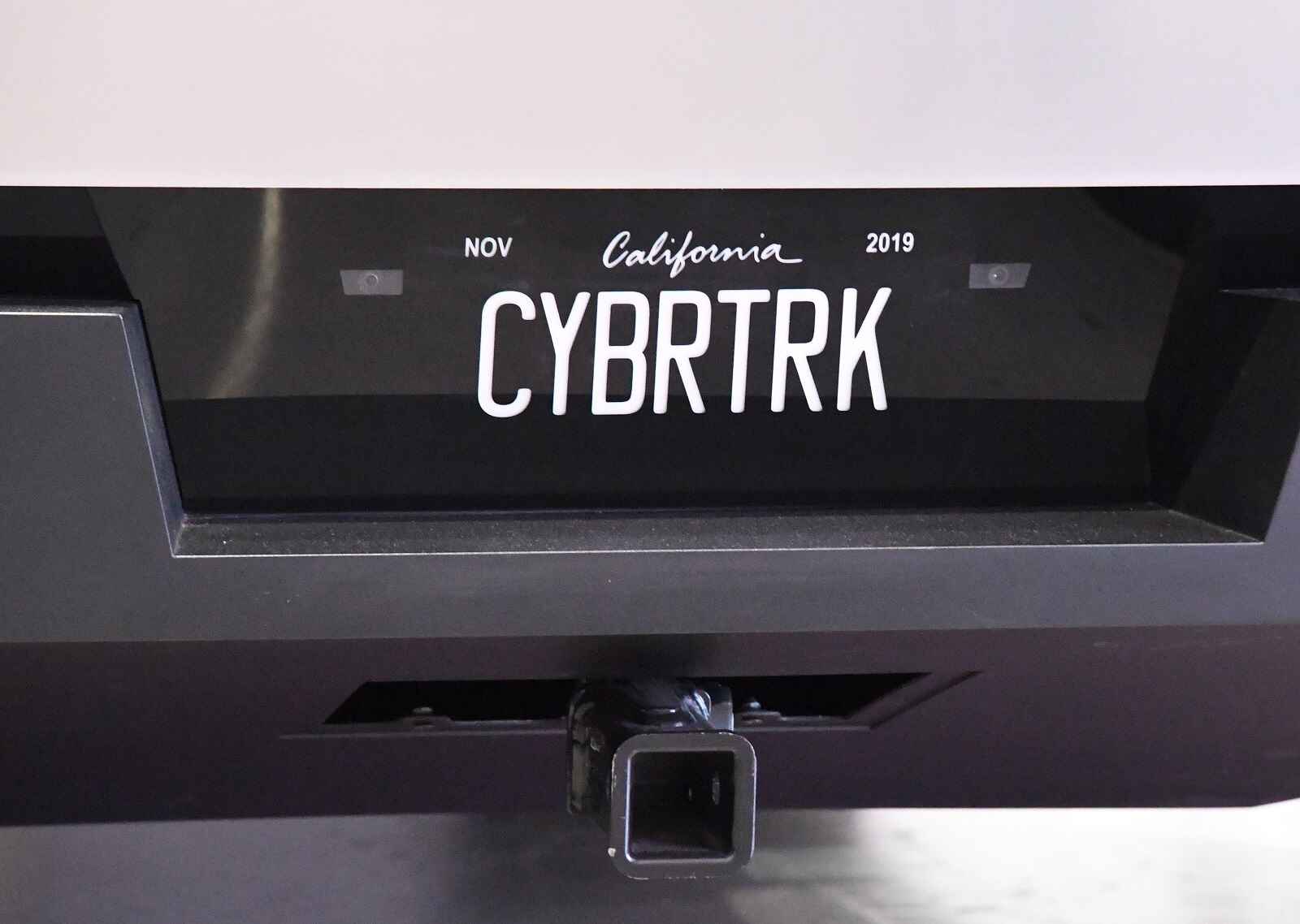 A Tesla Cybertruck rear bumer with hitch and license plate in close view