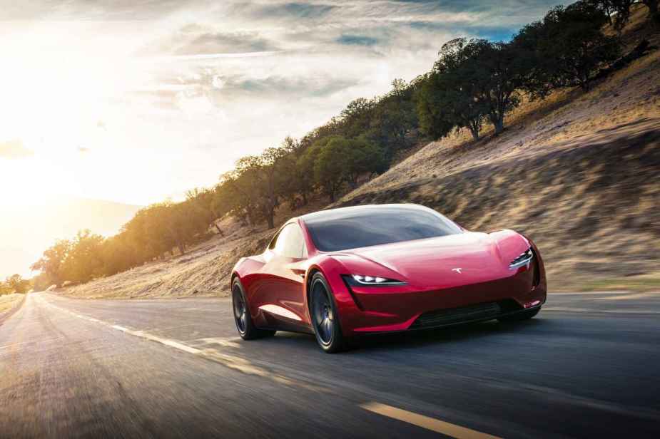 A red Tesla Roadster shown driving towards the viewer in right front angle view
