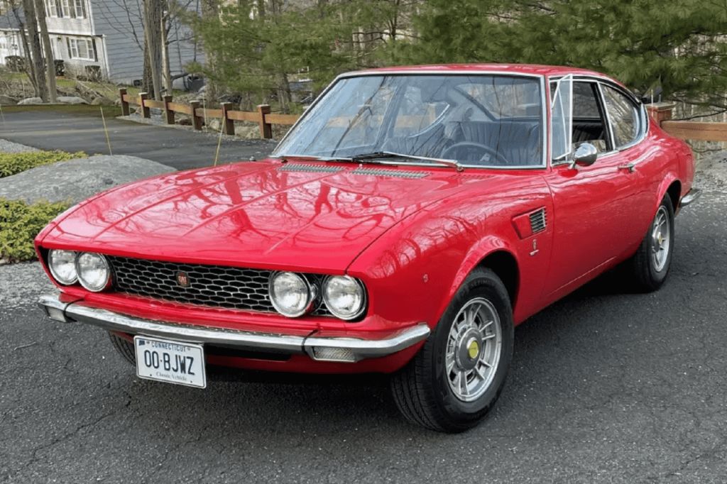 A red 1967 Fiat Dino parked in left front angle view