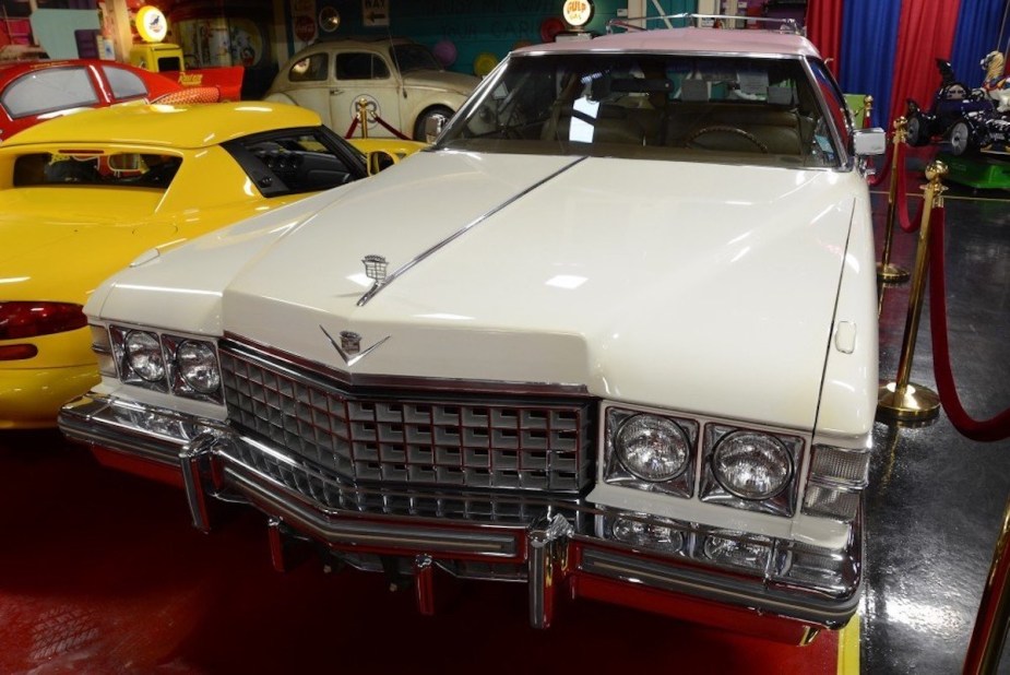 Grille of a white Cadillac DeVille station wagon conversion parked in a museum.
