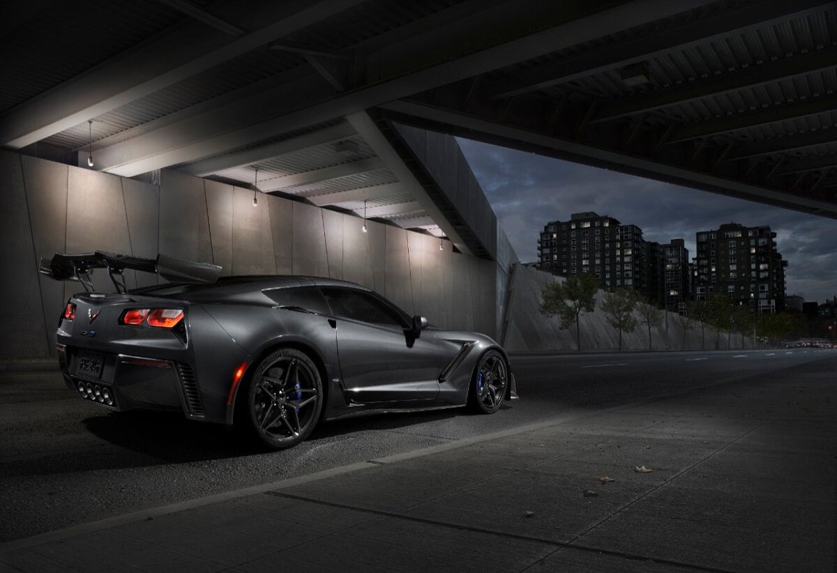A gray Chevrolet Corvette ZR1 from the C7 generation shows off its wing.