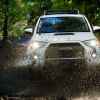 A white 2020 Toyota 4Runner TRD Pro in direct front view driving through large muddy puddle