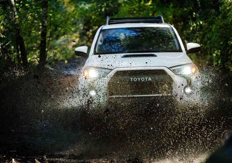 A white 2020 Toyota 4Runner TRD Pro in direct front view driving through large muddy puddle