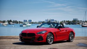 Red 2024 BMW Z4 parked by a marina.