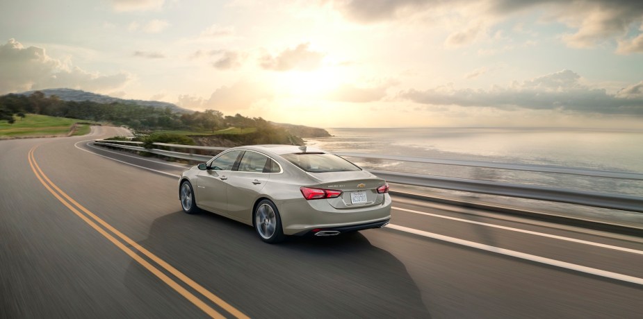 Chevrolet's Malibu sedan driving along a coast, the ocean visible in the background.