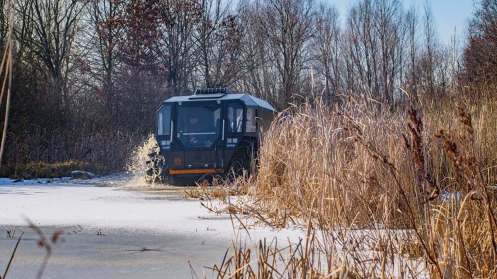 A SHERP amphibious vehicle wades through a frozen marsh. 