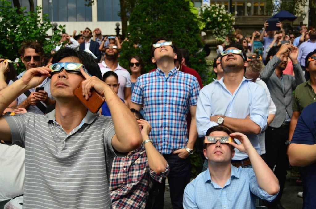 A group of people view a solar eclipse in 2024. 