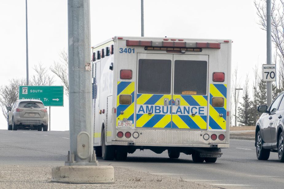 An ambulance driver drives the rig away from a photographer.