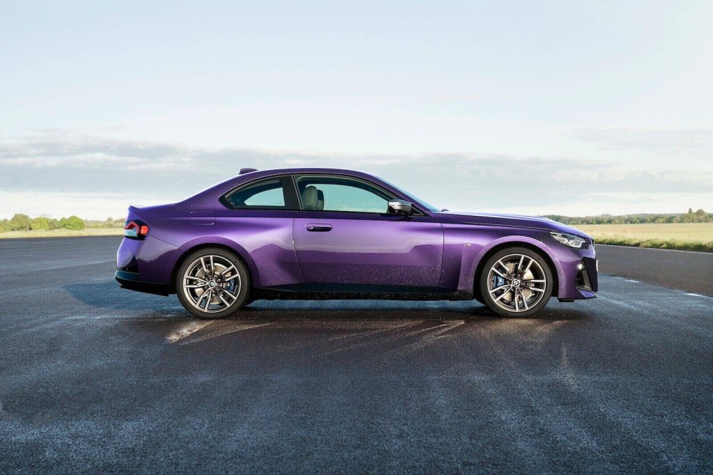 A purple BMW M240i xDrive shows off its side-profile on a track. 