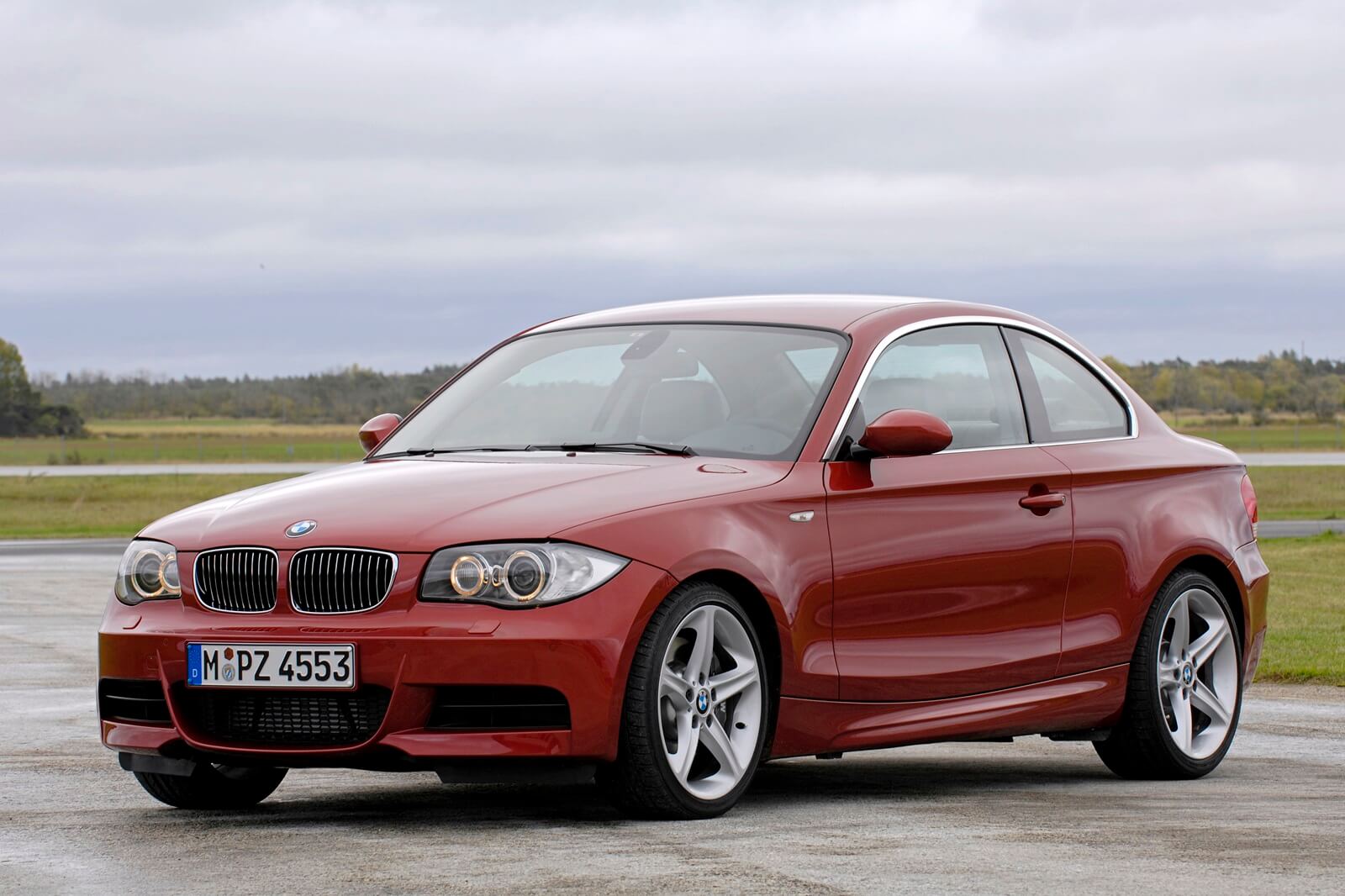 An E82 BMW 1 Series, like the 128i or 135i parks on a platform.