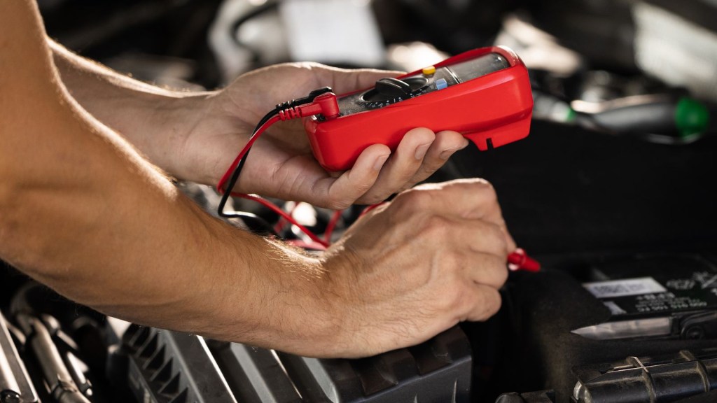 Person working on a car battery
