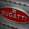 The red Bugatti logo stamped on the side of a metal engine block.