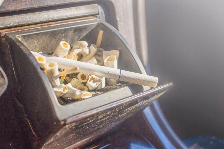 Car ashtray overflowing with cigarette butts