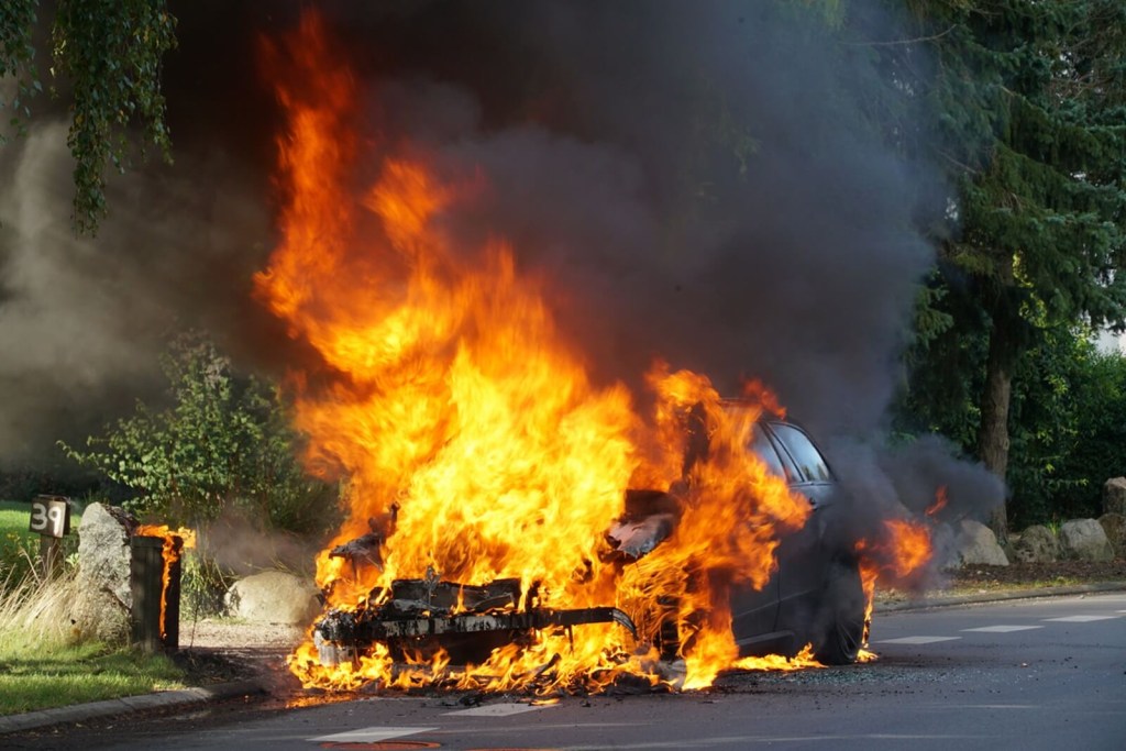 A car burning after it caught fire will require a call to a car insurance provider.