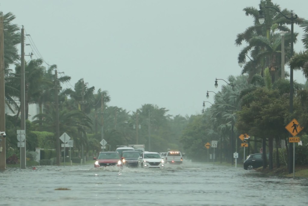 A group of Florida motorists drive through flood waters.