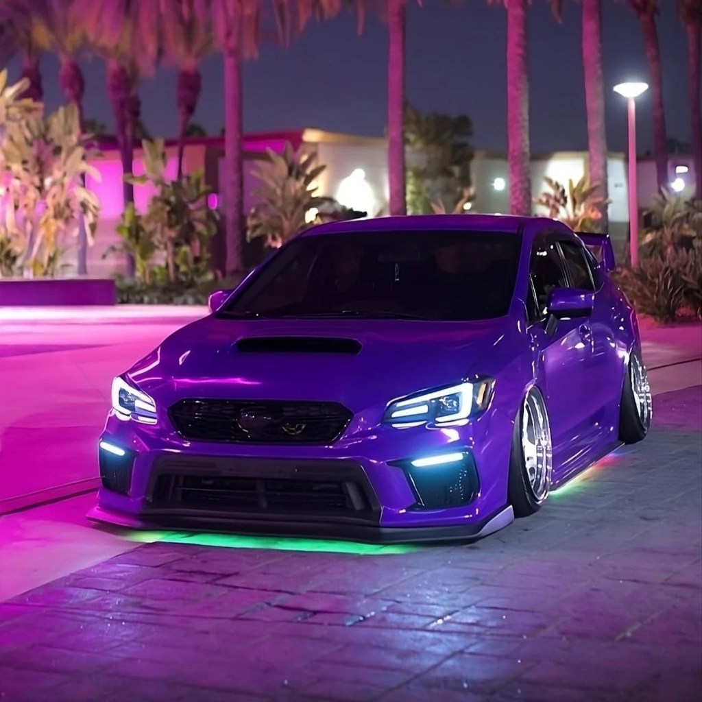 Purple car with green custom ground effects lighting kit by Underglow parked in front of palm trees.