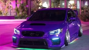 Purple car with green custom ground effects lighting kit by Underglow parked in front of palm trees.