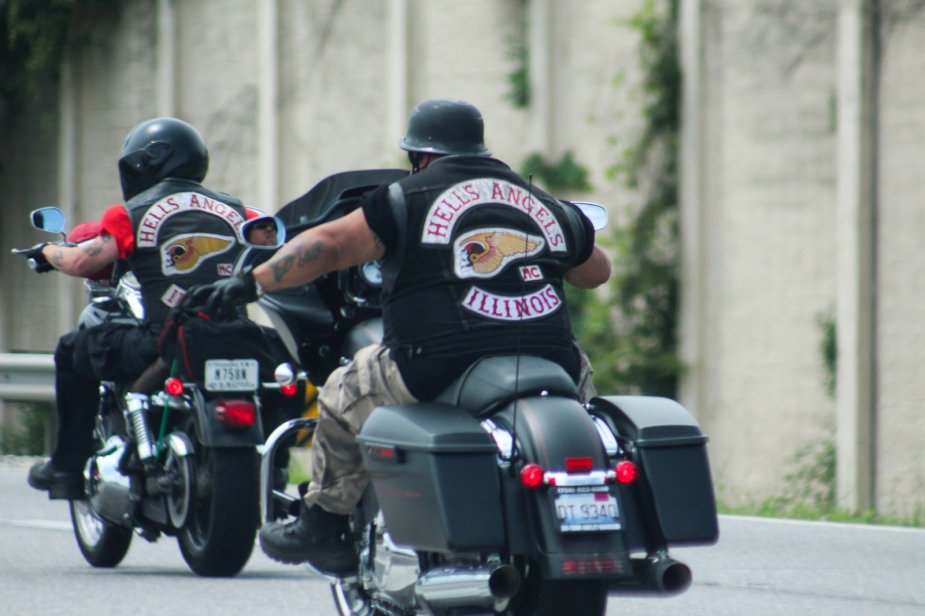 Two motorcyclists with Hell's Angels club patches ride on the interstate.