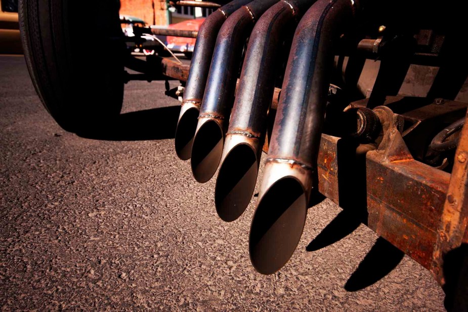 Closeup of the four performance exhaust pipes on one side of a hotrod 