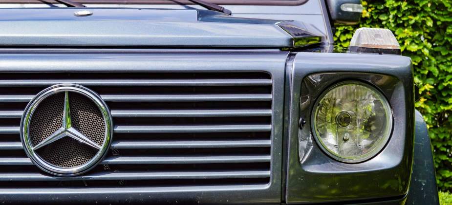 The Mercedes-Benz logo on the grille of a G-Class SUV.