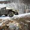 Military surplus Humvee SUV navigating an off-road trail.
