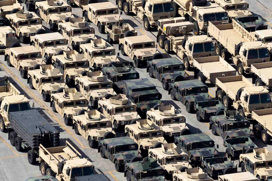 Parking lot full of surplus military vehicles.
