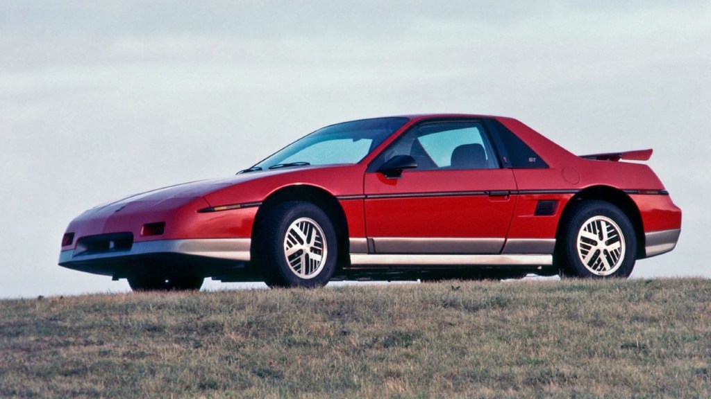 Red Pontiac Fiero, posed. This was one of the most dangerous and worst sports cars ever made.