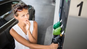 Woman chooses a fuel mix at a pump with ethanol mixes.