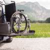 Wheelchair on a lift outside an adaptive van.